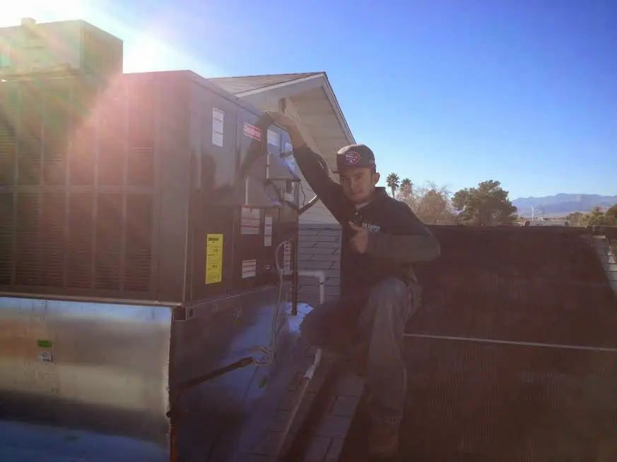 HVAC technician performing Air Duct Cleaning on a rooftop unit in Westchester